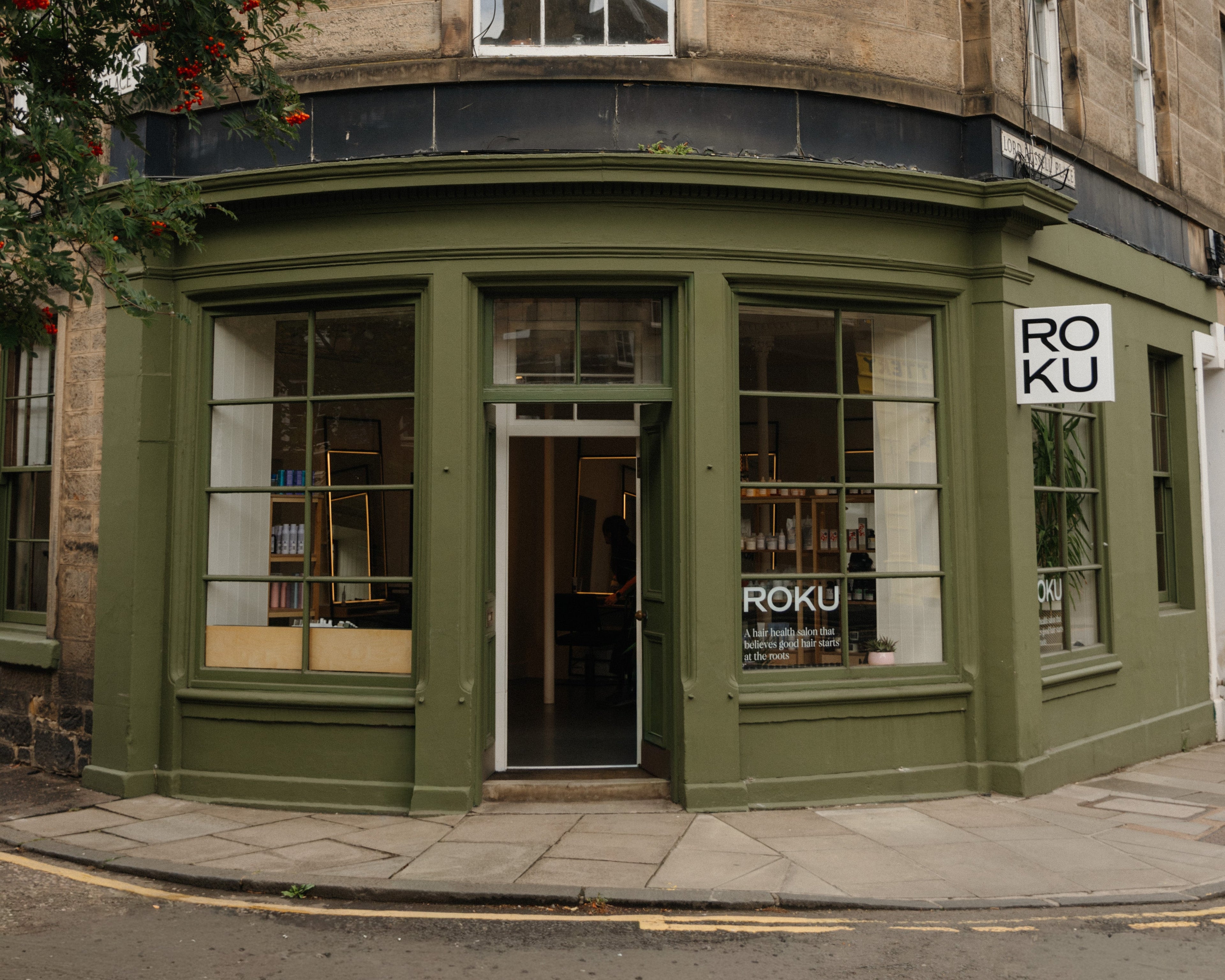 Corner building with green trim and 'ROKU' branding on a street corner.
